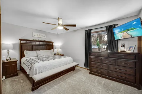 a bedroom with a bed and a large closet with wooden floor