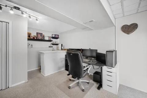 a view of a workspace with furniture and a window