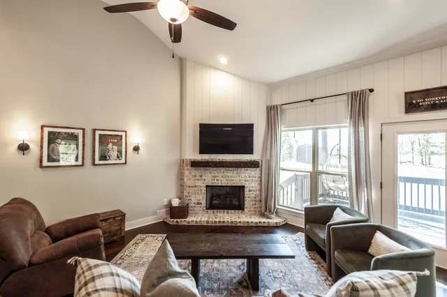 a living room with furniture a fireplace and a flat screen tv