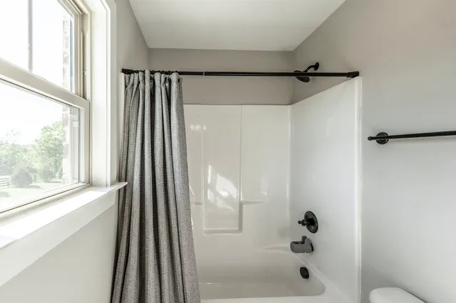 a bathroom with granite countertop double vanity and mirror