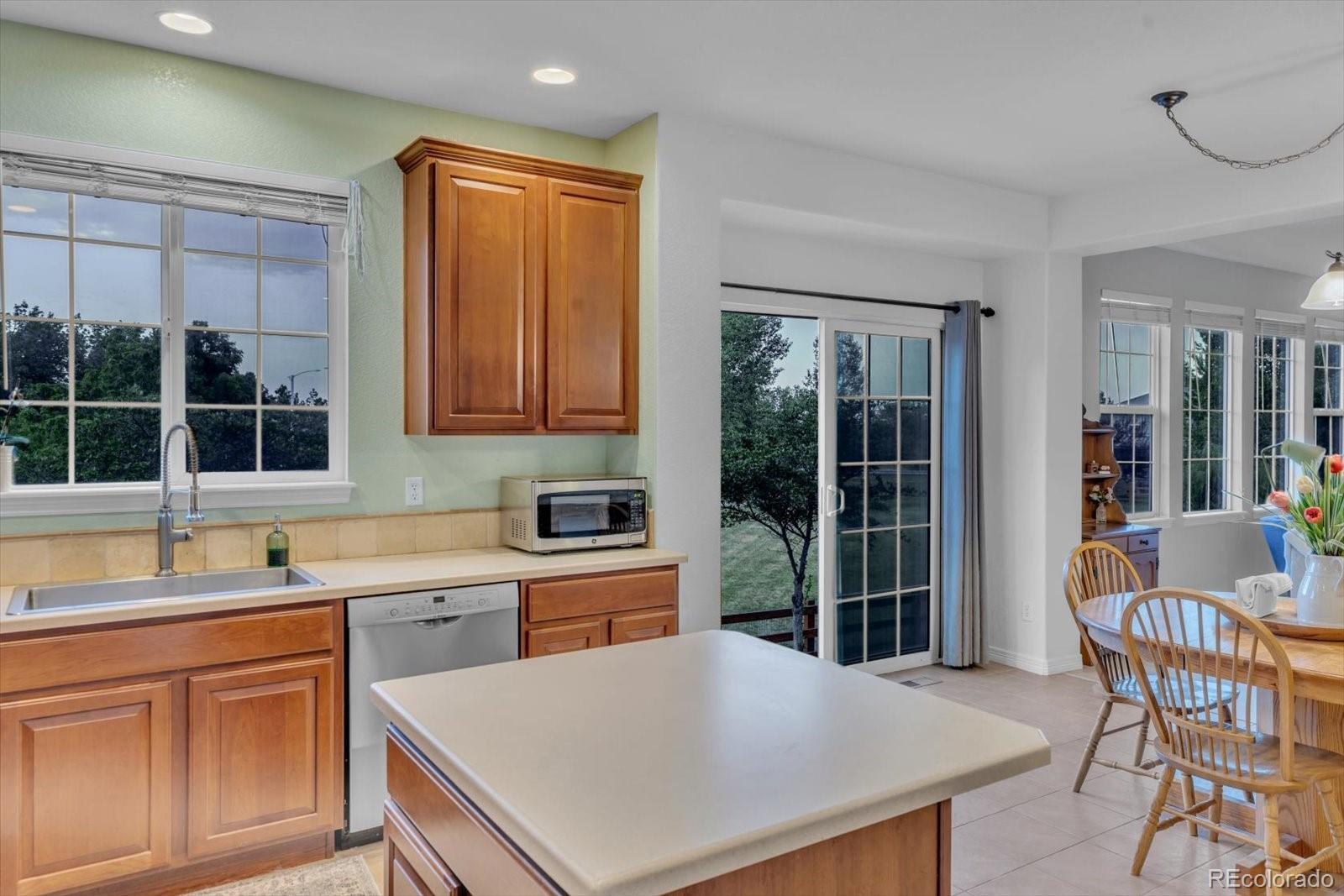 4786 Rabbit Mountain Road Broomfield, CO 80020 - Photo 13 of 41 a kitchen with a table chairs sink and cabinets