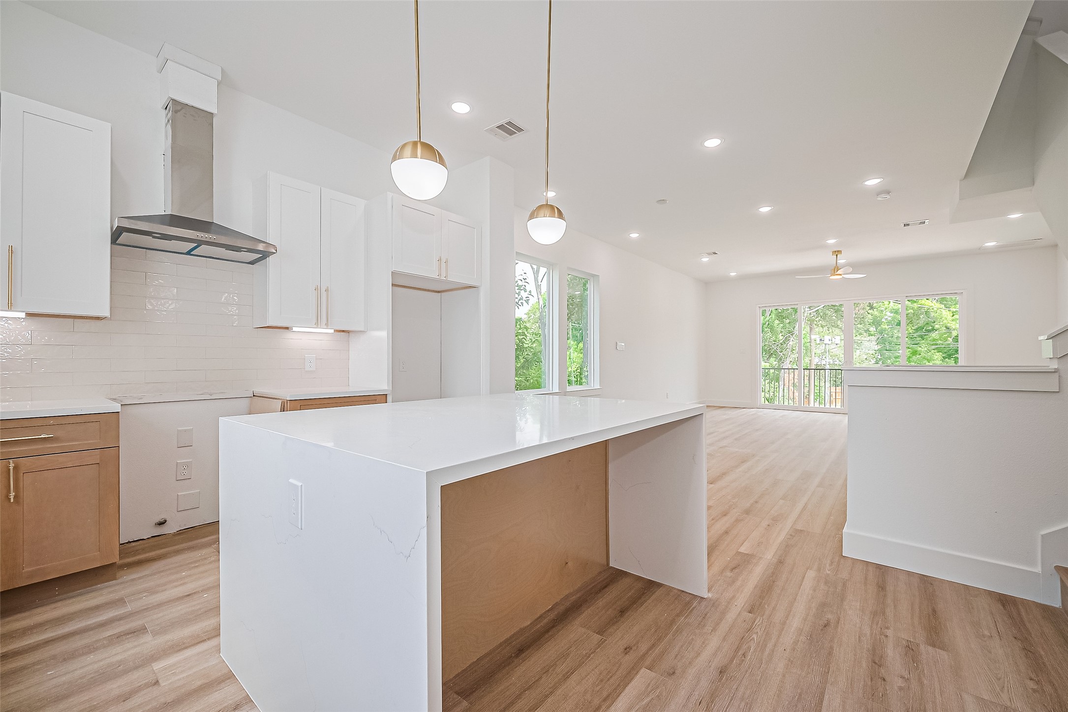 6023 Maybell Street Houston, TX 77091 - Photo 14 of 37 a kitchen with kitchen island white cabinets and wooden floor