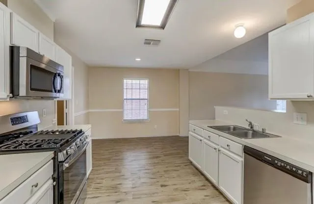 a kitchen with granite countertop a sink stove and refrigerator