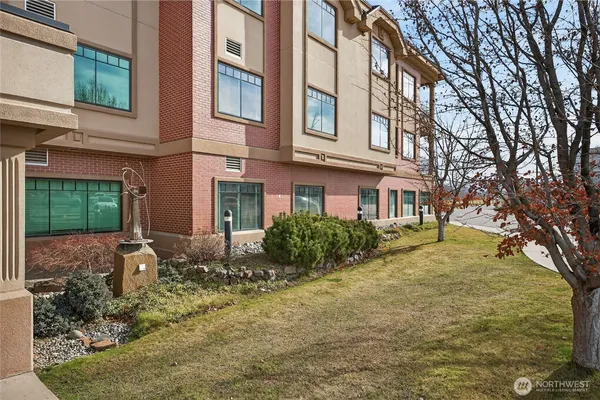 a view of a brick building next to a yard