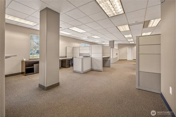a view of a workspace with furniture and a window