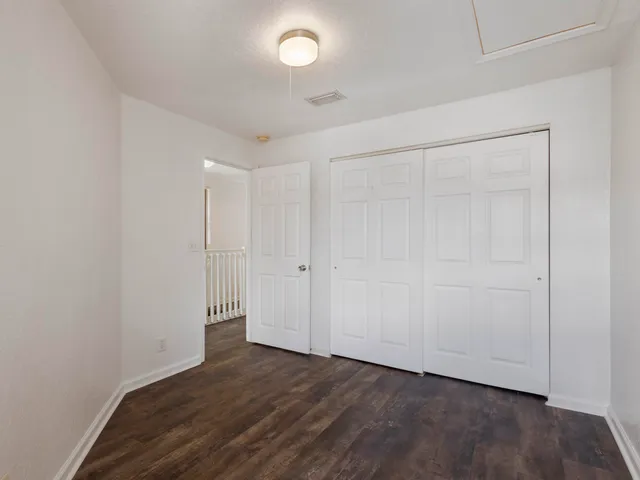 an empty room with wooden floor and closet