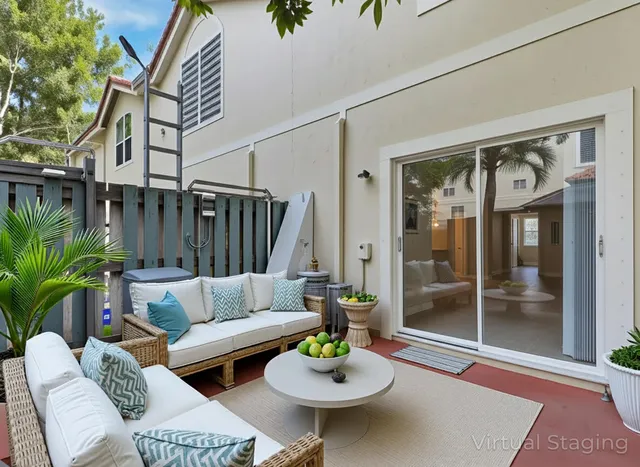 a view of a patio with couches and a table and potted plants with wooden floor