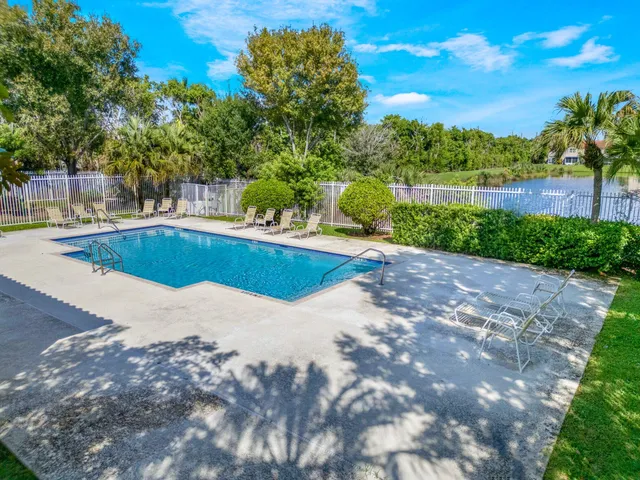 a view of a swimming pool with a patio and a yard