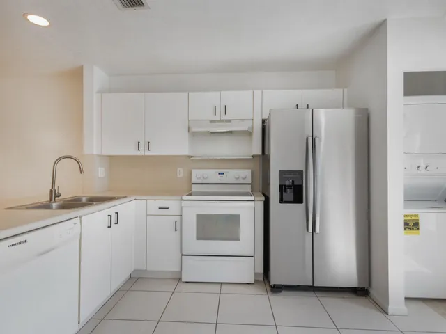 a kitchen with stainless steel appliances white cabinets and a sink