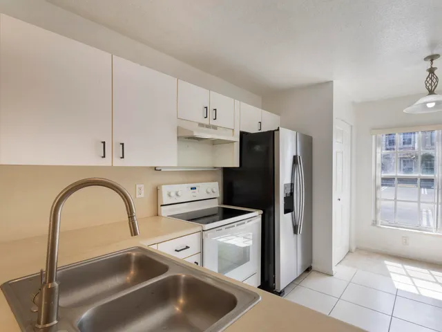 a kitchen with a refrigerator sink and cabinets