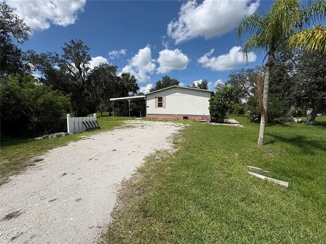 a view of a house with a yard and pathway