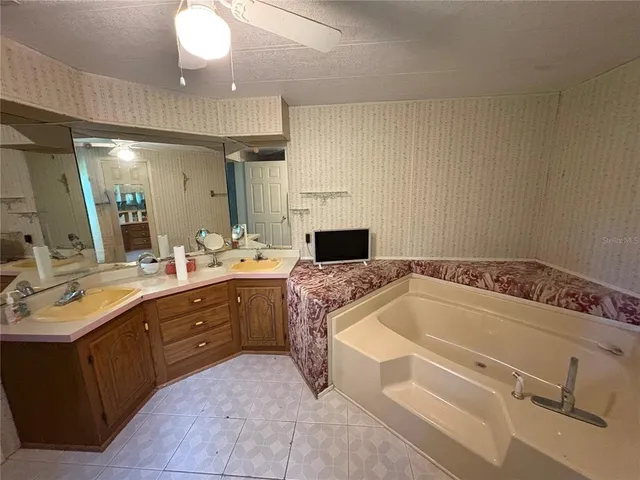 a bathroom with a tub sink and mirror