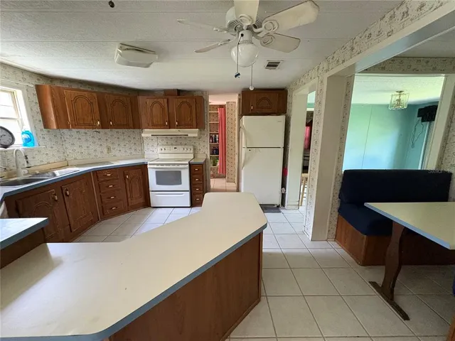 a view of kitchen with kitchen island granite countertop a refrigerator and a counter top space