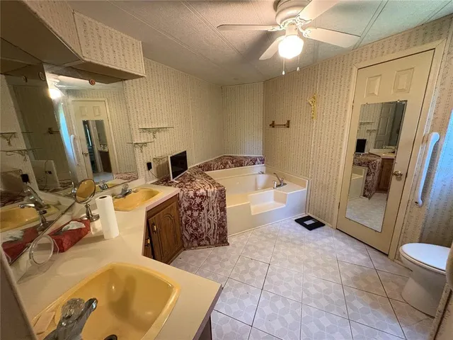 a spacious bathroom with a tub sink and mirror
