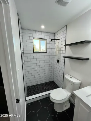 a bathroom with a toilet and a shower