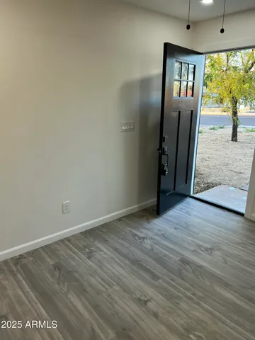 an empty room with wooden floor and a window