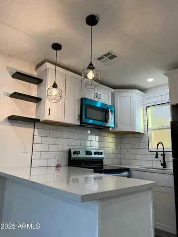 a kitchen with stainless steel appliances granite countertop a sink a stove and cabinets