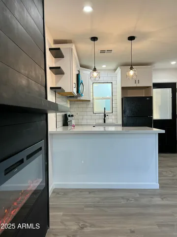 a view of kitchen with kitchen island stainless steel appliances a sink and a microwave