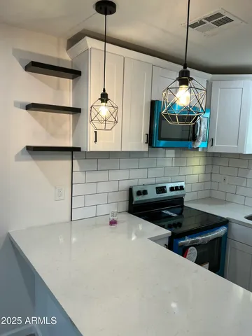 a kitchen with stainless steel appliances granite countertop a sink a stove and a microwave