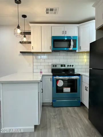 a kitchen with stainless steel appliances granite countertop a stove a microwave and a refrigerator