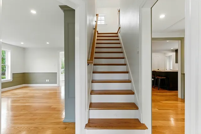 a view of a hall with wooden floor and stairs