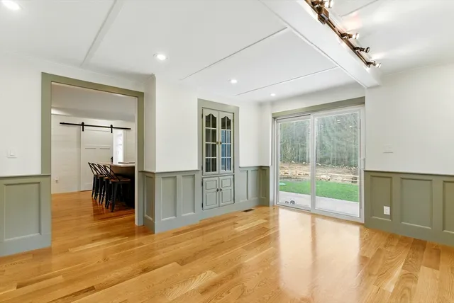 a view of empty room with wooden floor and floor to ceiling window