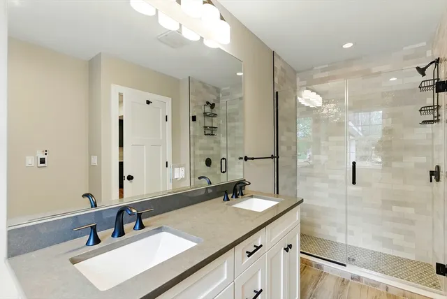 a bathroom with a sink double vanity and a shower