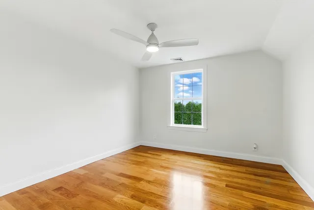 an empty room with a window and ceiling fan