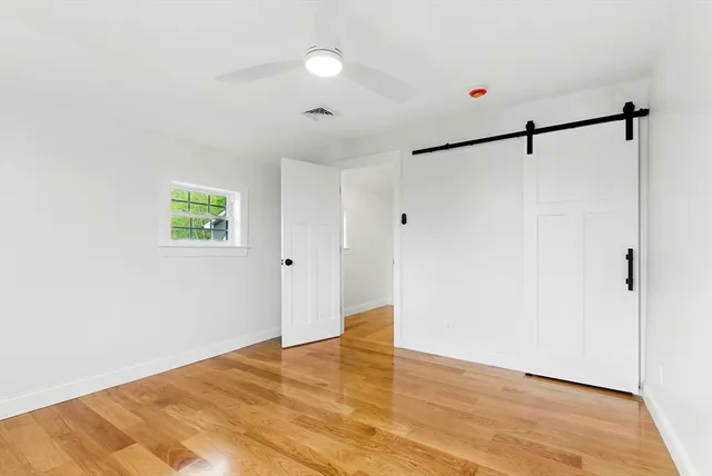 a view of a room with wooden floor and white walls