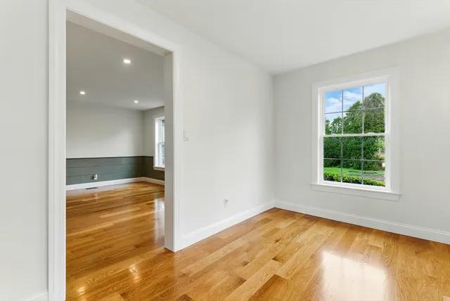 a view of empty room with wooden floor