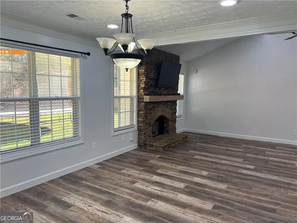 a view of empty room with fireplace and windows