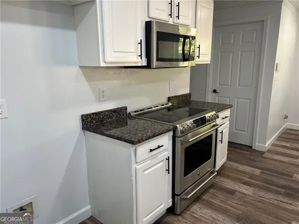 a kitchen with stainless steel appliances white cabinets and a stove top oven