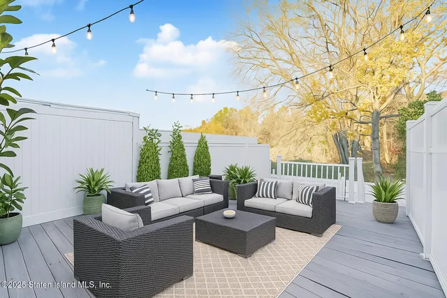 a roof deck with couches and potted plant