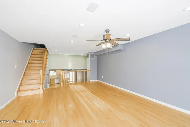 a view of a room with wooden floor and ceiling fan