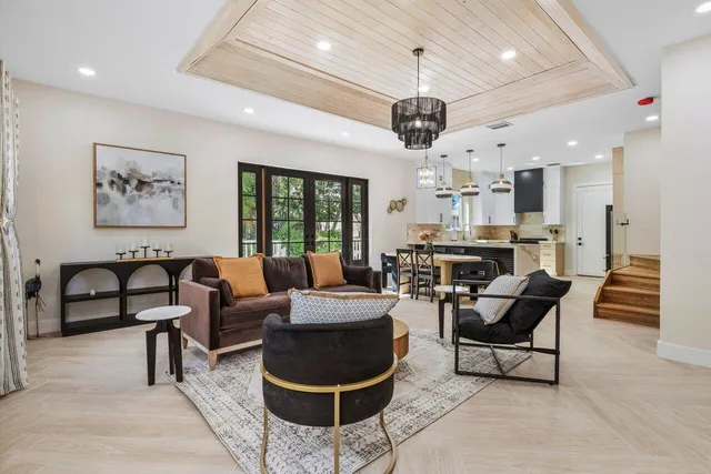 a living room with furniture a flat screen tv and a large window