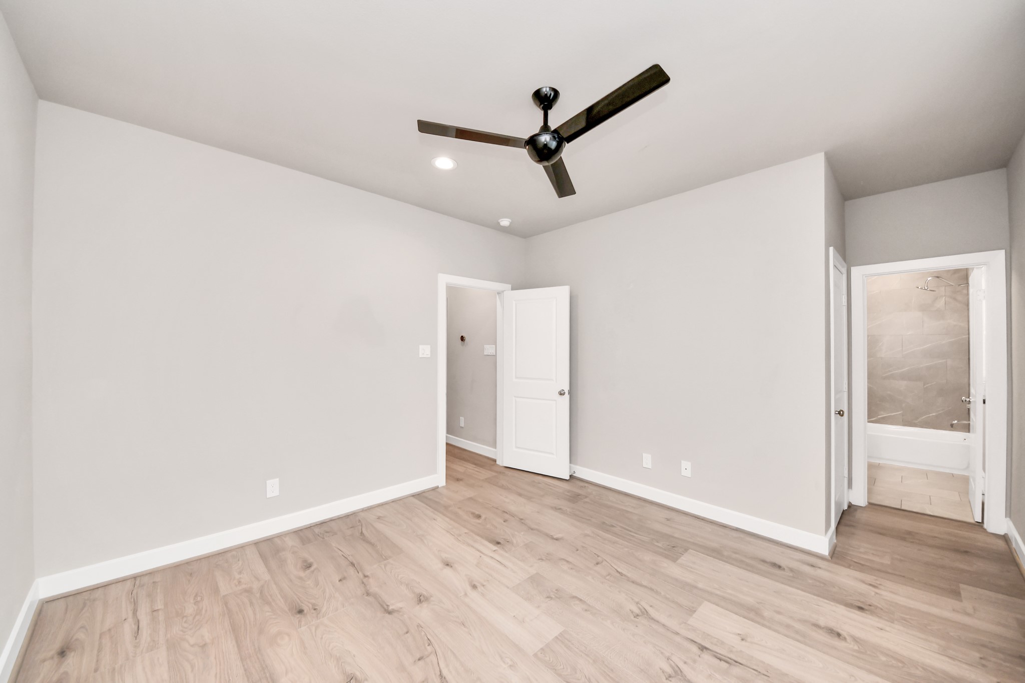2114 Stuart Street Houston, TX 77004 - Photo 26 of 39 a view of a big room with wooden floor and a ceiling fan