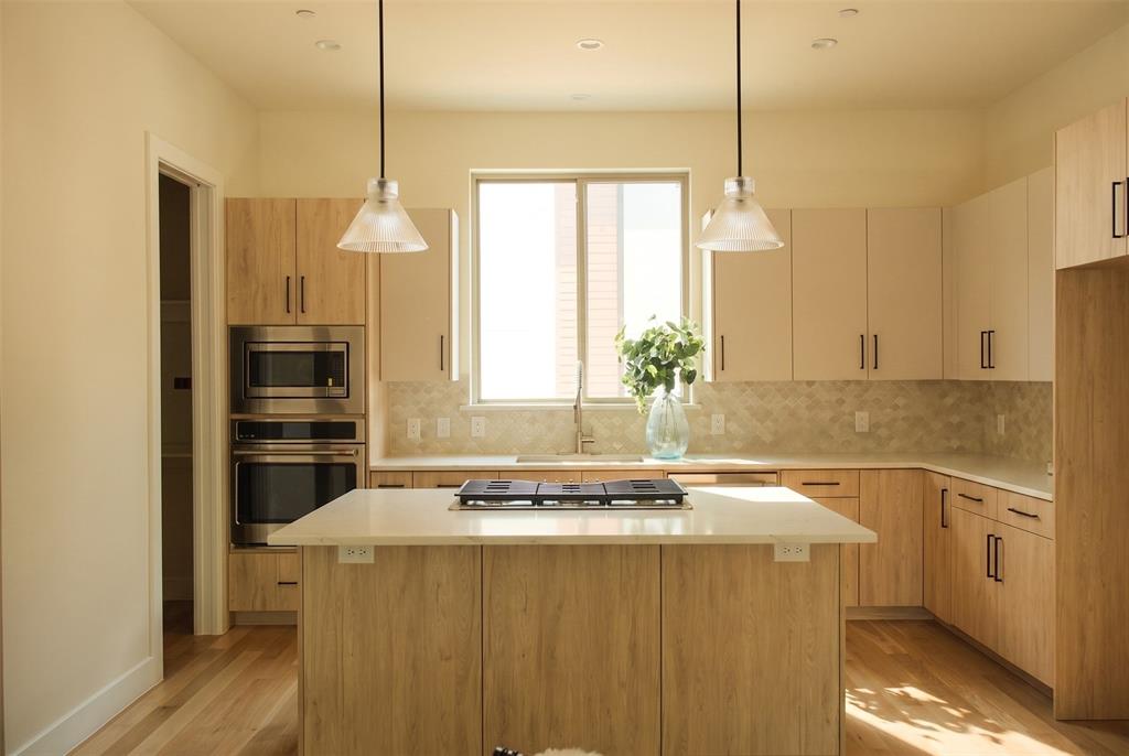 13900 Noel Road, Unit 202 Dallas, TX 75240 - Photo 5 of 23 Kitchen featuring quartzite countertops, GE Cafe series appliances and Visual Comfort light fixtures
