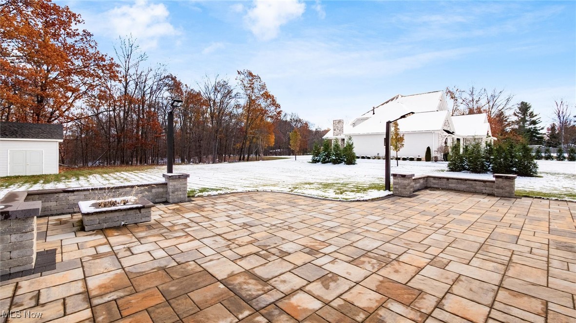4641 Foote Road Medina, OH 44256 - Photo 43 of 46 Snow covered patio featuring an outdoor fire pit, a patio area, and a shed