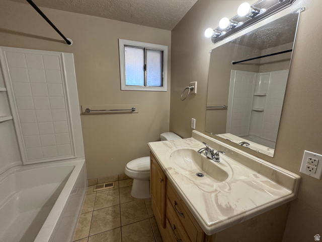 2182 West 5600th Street South Roy, UT 84067 - Photo 8 of 11 Bathroom featuring a single vanity with wood-finish cabinetry, a large mirror, and a tub/shower combination with a tiled surround