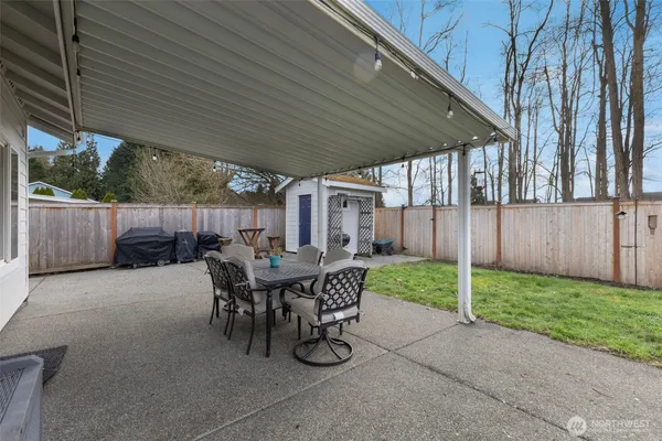 a view of a backyard with table and chairs and wooden fence