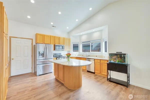a kitchen with stainless steel appliances granite countertop a sink stove and refrigerator