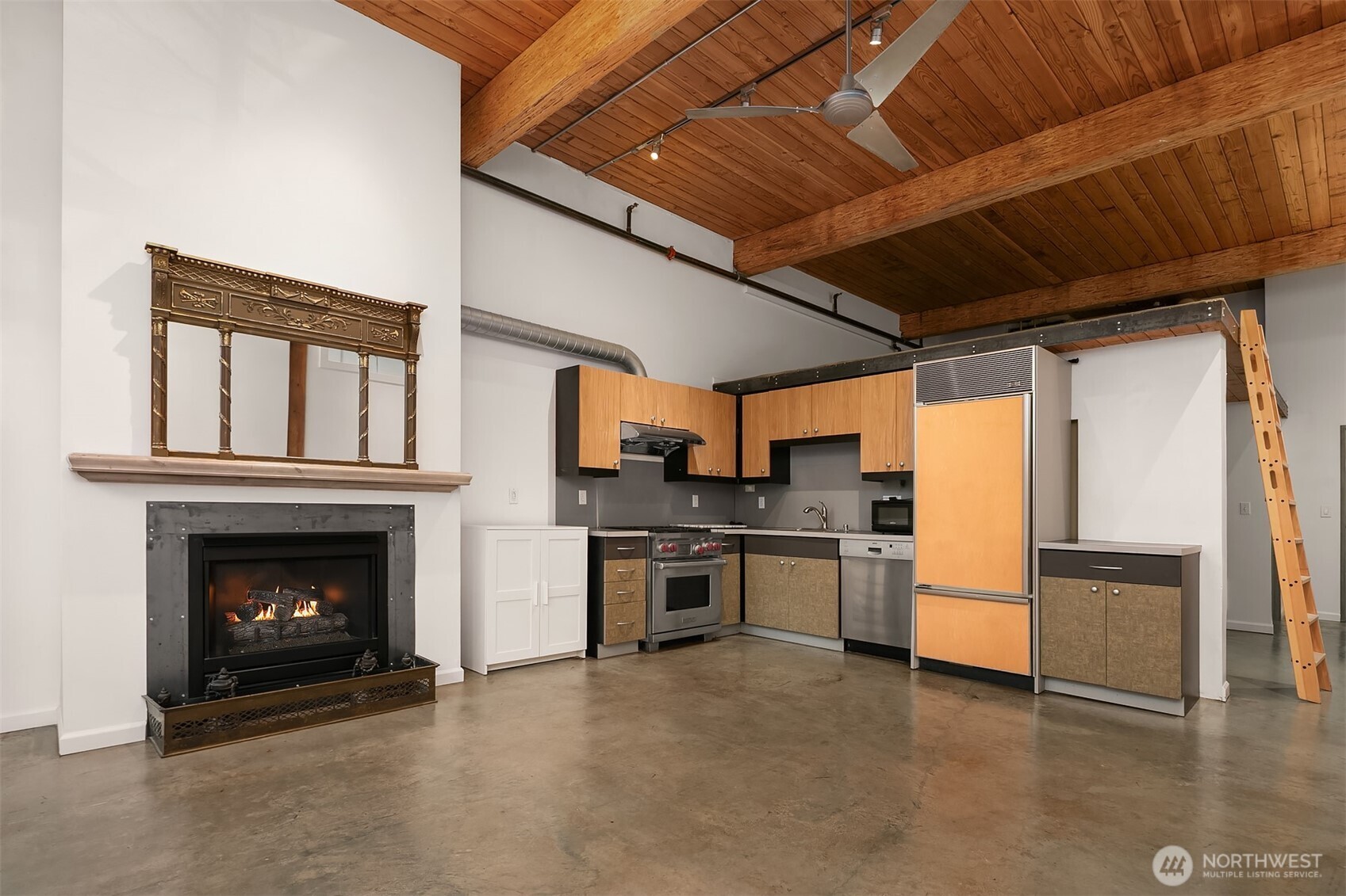 1812 19th Avenue, Unit 103 Seattle, WA 98122 - Photo 3 of 14 a kitchen with stainless steel appliances granite countertop a refrigerator a stove and a sink with wooden floor
