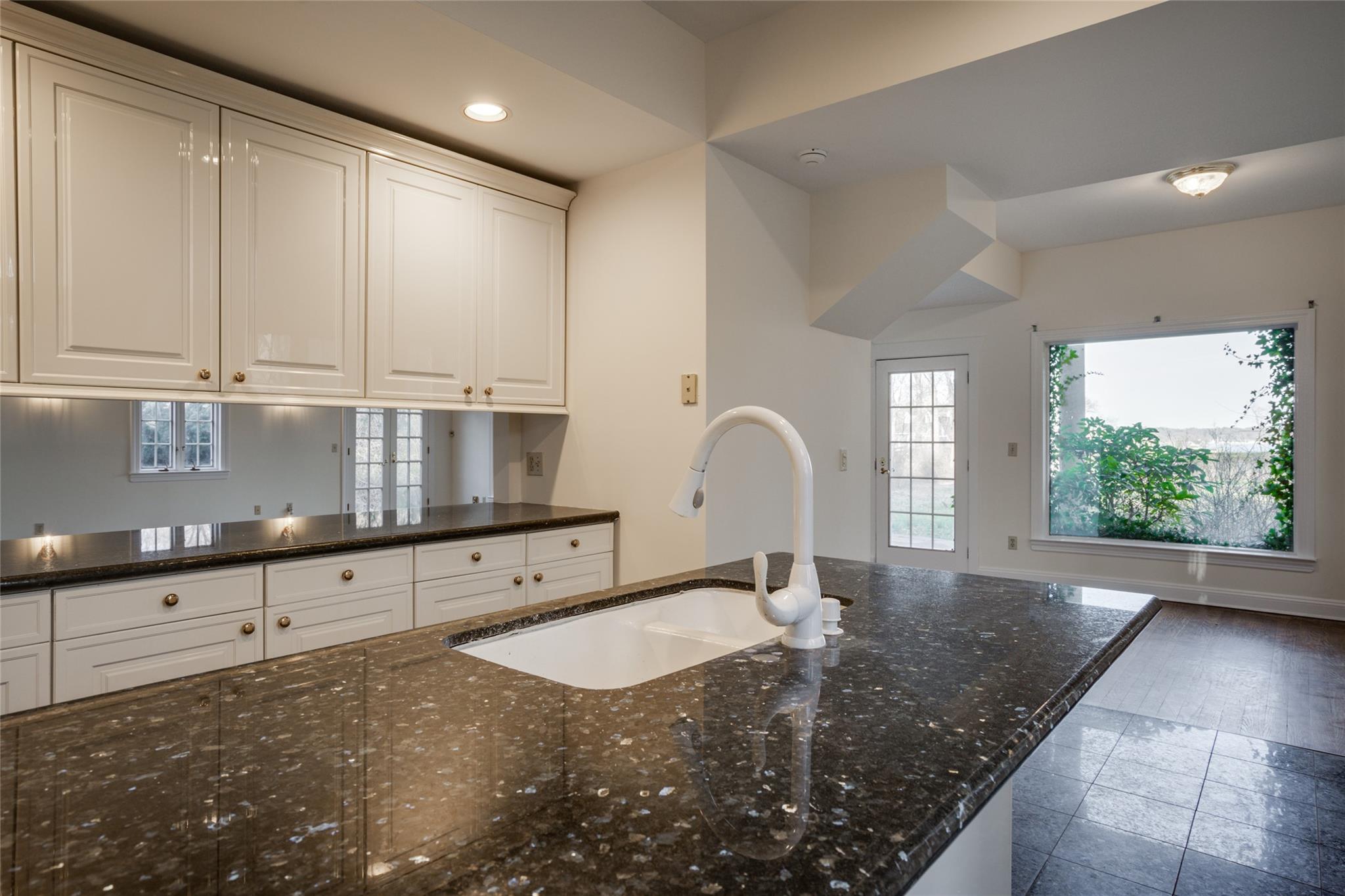 358 Centre Island Road Centre Island, NY 11771 - Photo 16 of 39 a kitchen with granite countertop white cabinets a sink a window and stainless steel appliances