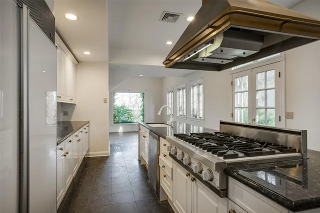 a kitchen with stainless steel appliances granite countertop a stove and a wooden floors