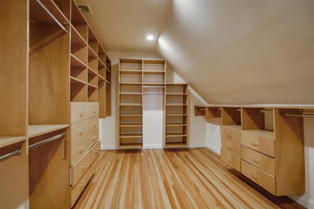 a view of walk in closet with empty racks