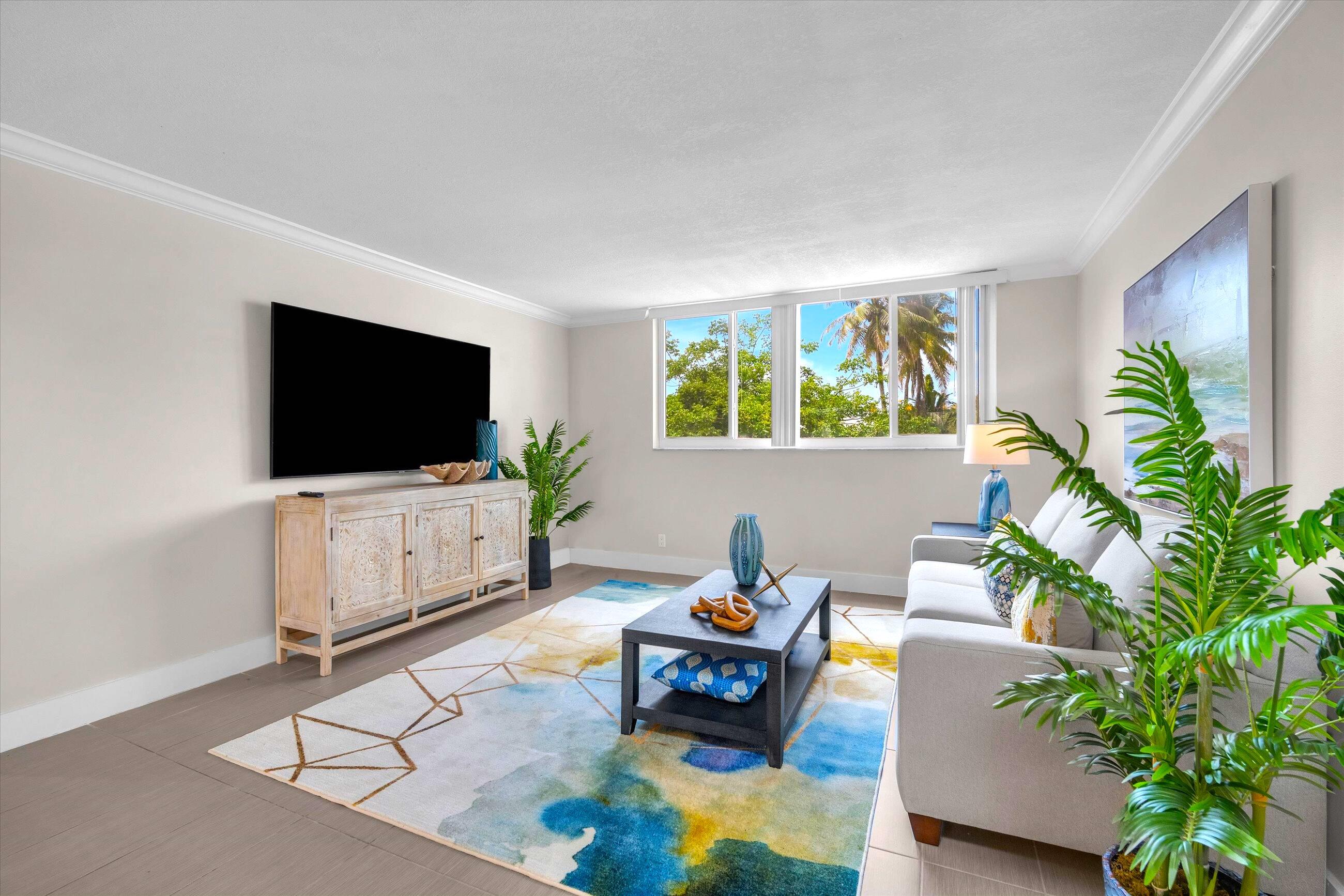 601 North Ocean Boulevard, Unit 203 Boca Raton, FL 33432 - Photo 9 of 20 a living room with furniture and a flat screen tv