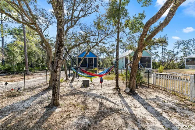 a view of a backyard with table and chairs under an umbrella