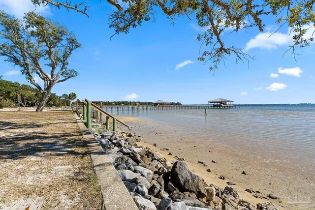 a view of a field with an tree and car parked