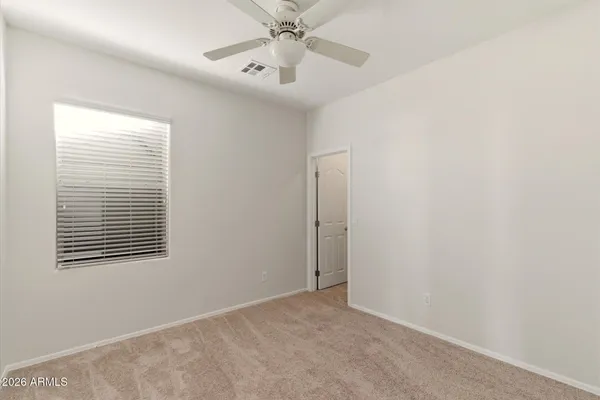 an empty room with windows and fan