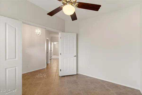 a view of an empty room and chandelier fan